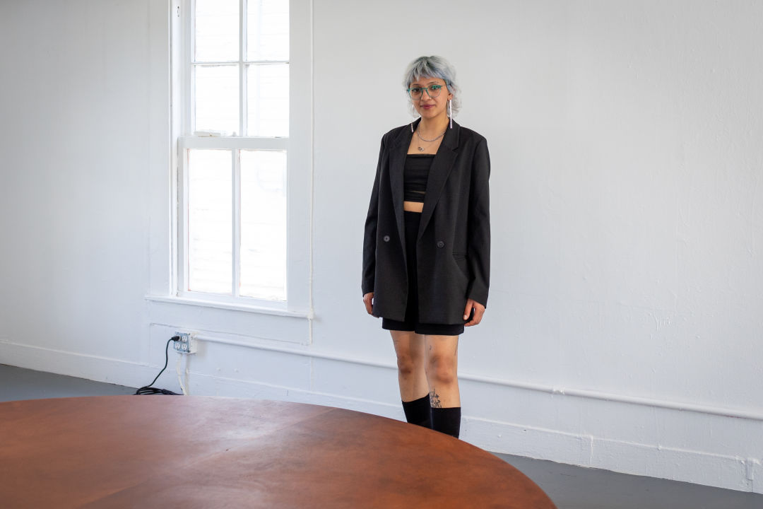 A person stands behind a table in a white house.