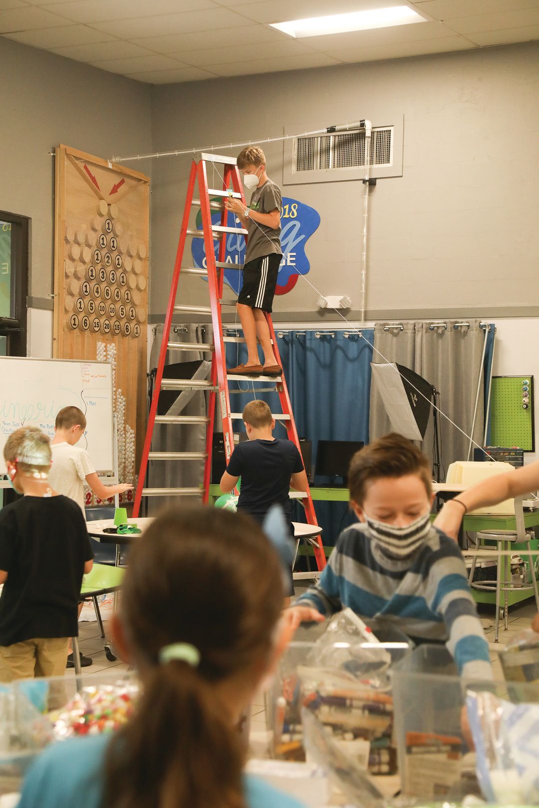 Youngsters in a recent STEM Saturday lab get ready for a classic physics experiament, the egg drop, to learn about the relationship between force and momentum.