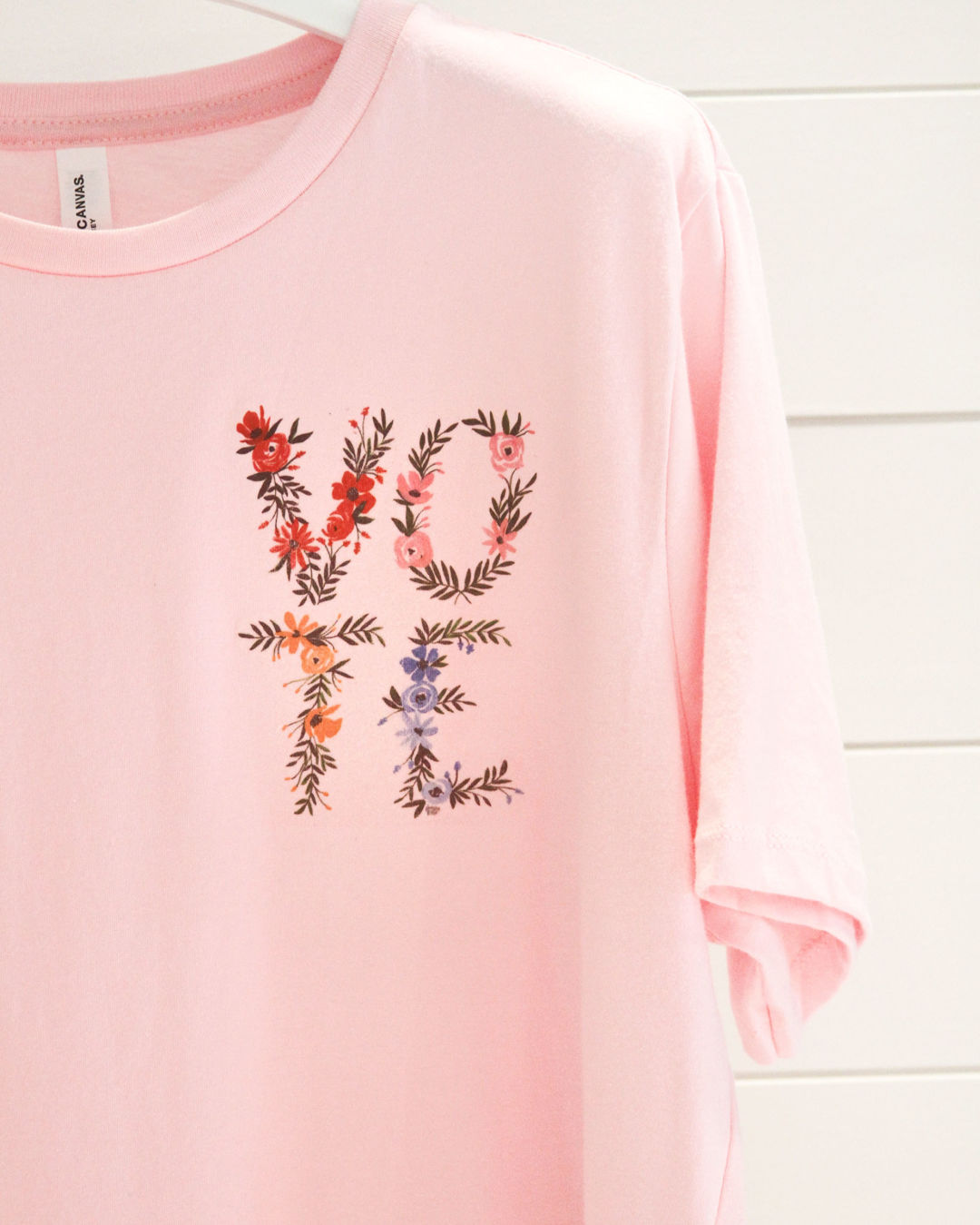 The Camilyn Beth x Shannon Kirsten Vote t-shirt features Kirsten's floral illustration on a light pink tee.