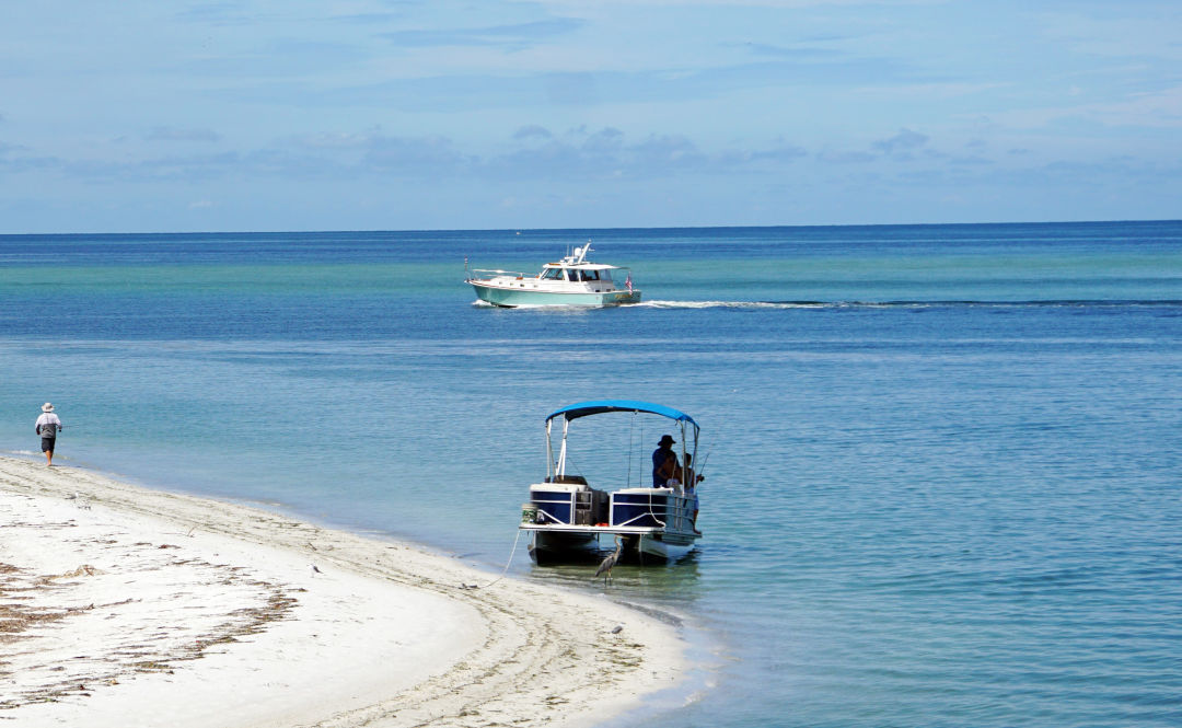 Boaters and beachgoers enjoy the blue-green waters of Sarasota Bay, whose health is improving.