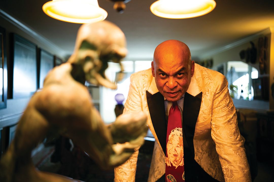 Reggie Williams stands next to one of the pieces in his art collection, a sculpture of a rugby player, in his downtown Sarasota condo.