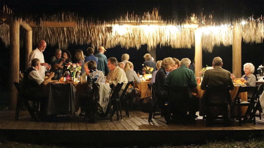 Environmental leaders gather under a chickee hut for Moore's Marsh Madness event.