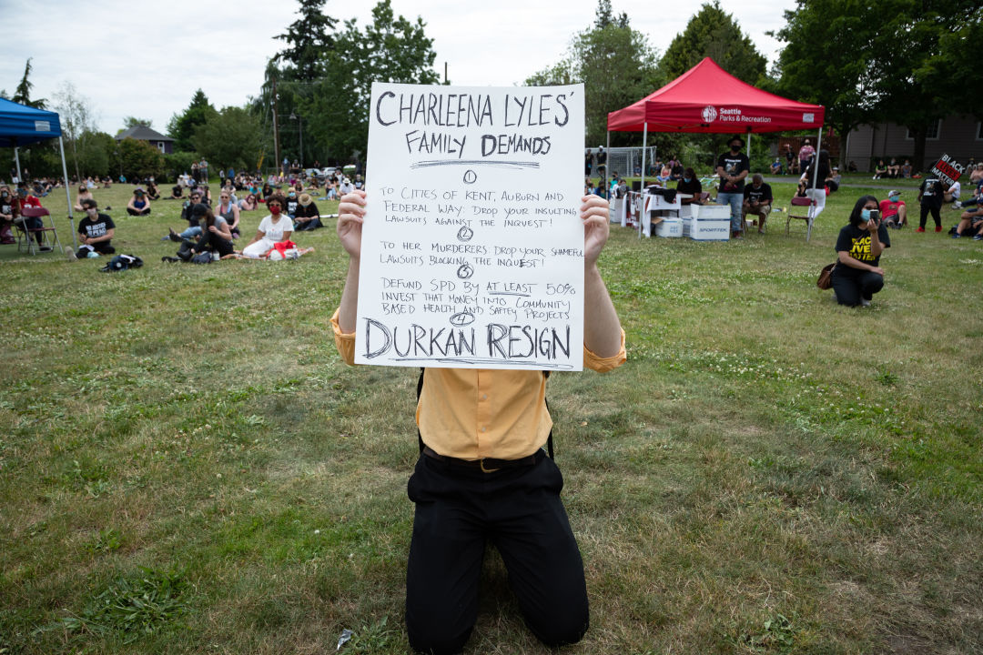 A protester holding a sign demanding justice for Charleena Lyles and for Mayor Jenny Durkan to resign, at a rally for Not This Time on June 19, 2020.