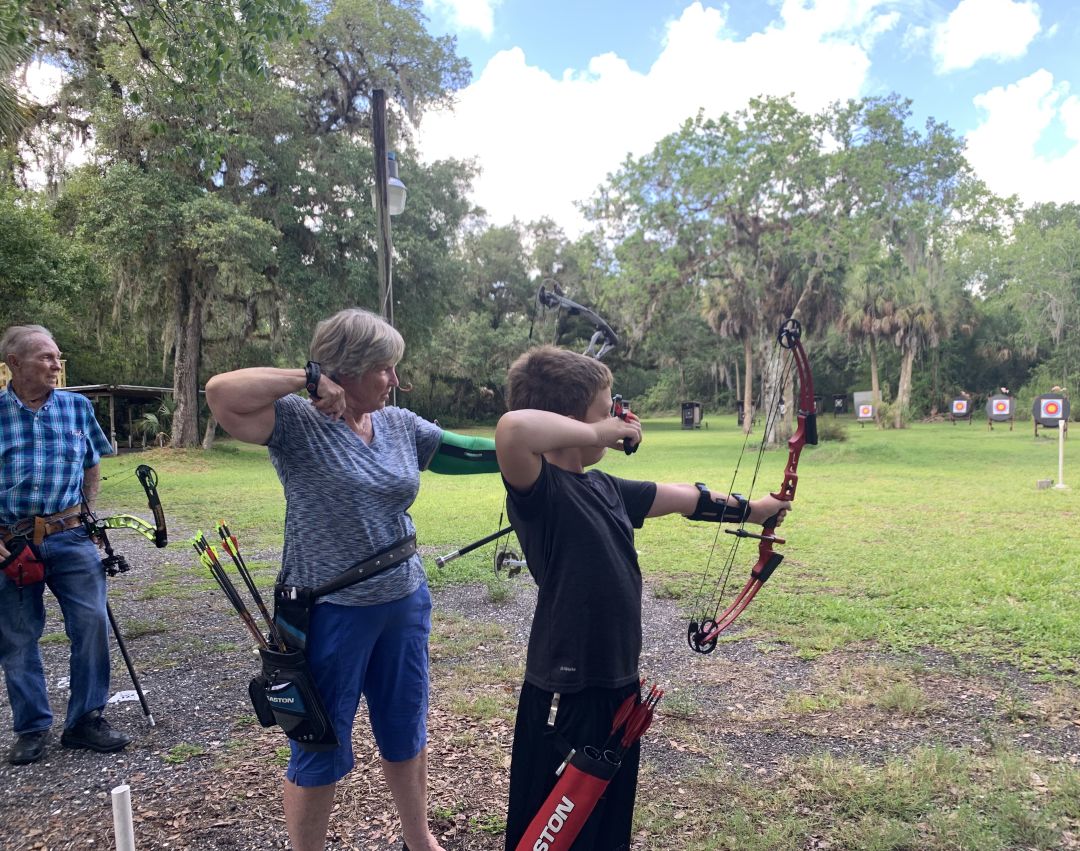 Myers and Alice Parrish teaching their grandson Roscoe how to shoot.