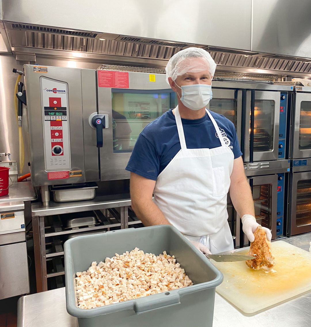 A Meals On Wheels of Sarasota volunteer prepares food.