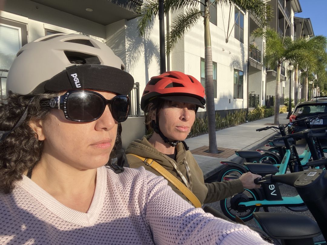 Two friends at a Veo scooter corral in Sarasota.