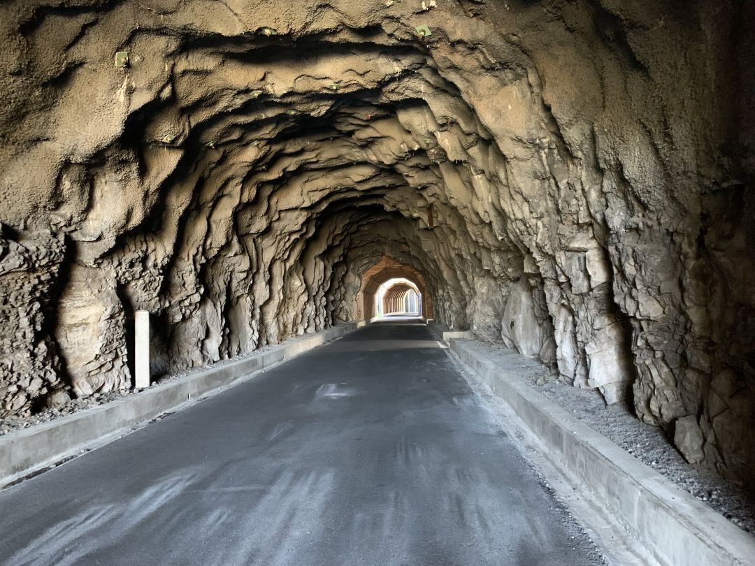 grotto like rock walled tunnel with paved path
