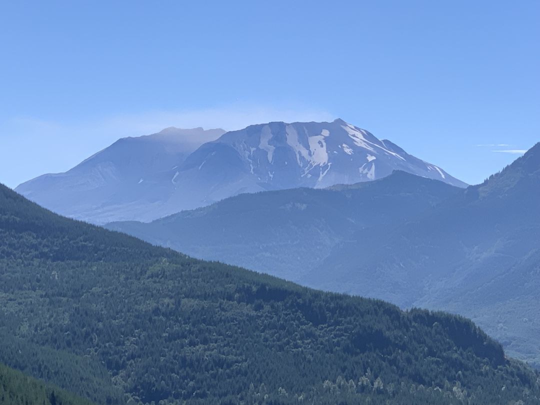 Mount St. Helens seen from the west, with some green ridges in front of it