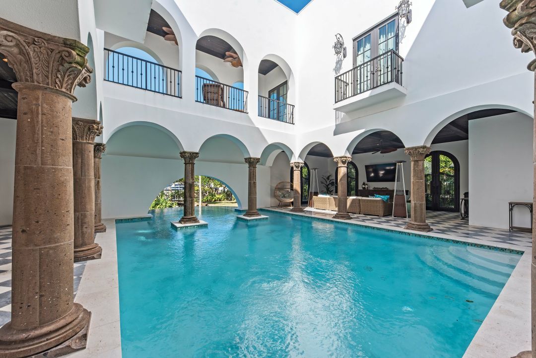 Stone and marble columns add an ancient Roman touch and natural light floods the space thanks to a cutout above.