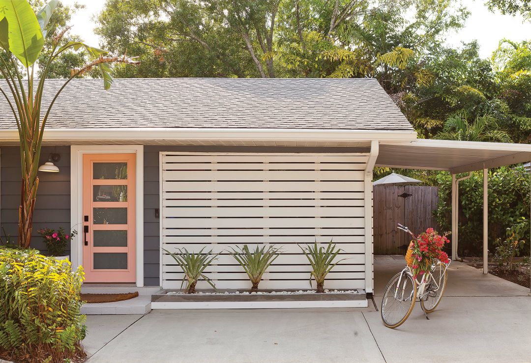 Casey Stephenson's cheerful pink front door pops against her home's dark gray exterior.