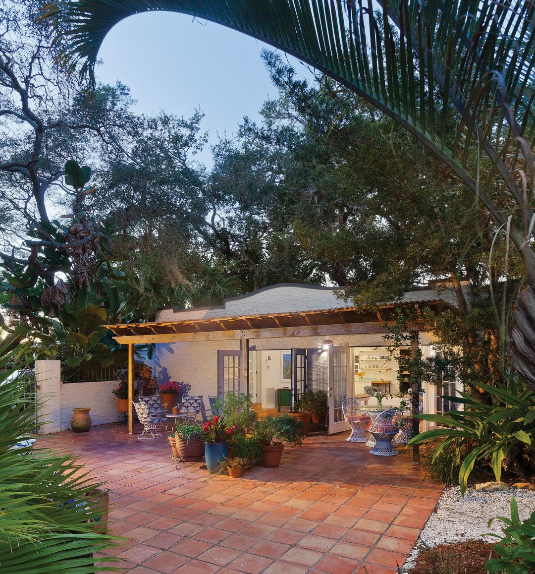 Outdoor seating and cheerful potted plants invite a pause.