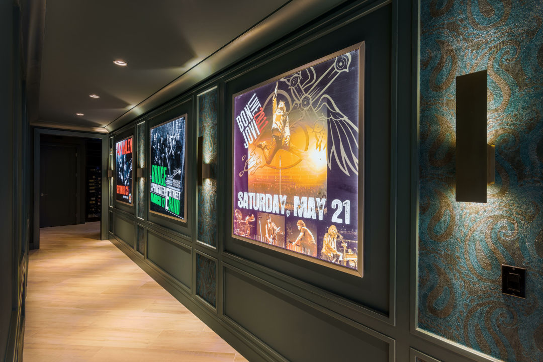 A hallway with posters framed in wall trim and panels.