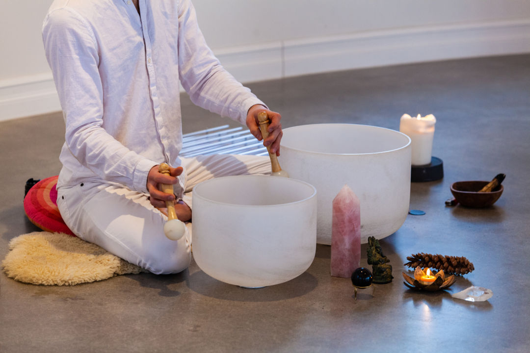 A man plays crystal singing bowls