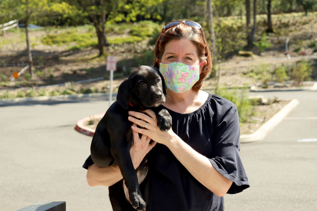 Black puppy with new mom