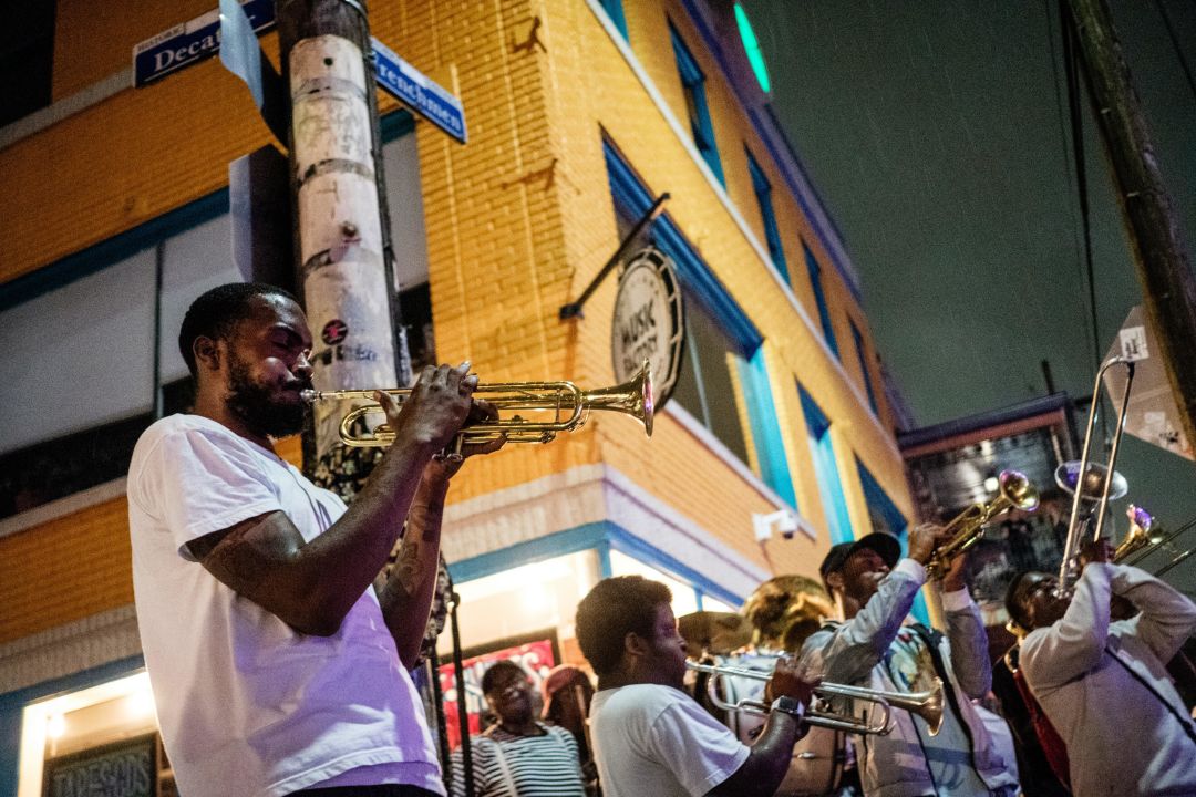 Horn players on a street corner at night