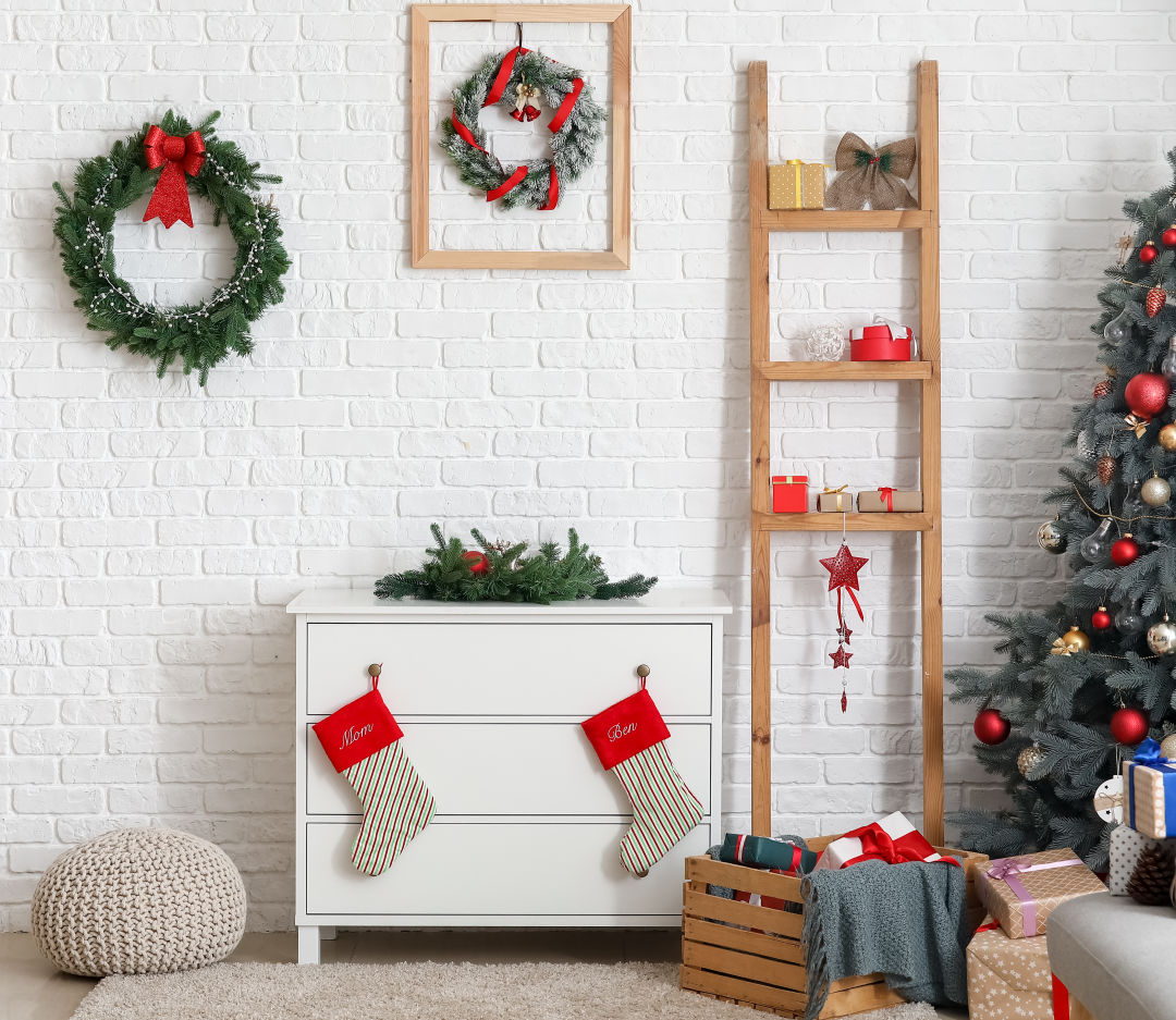 christmas stockings hang from a ladder and drawer dresser knobs.