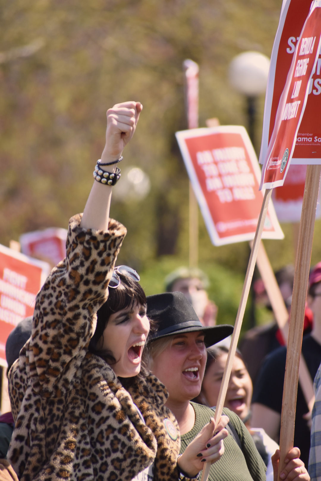 A person raises a fist and yells at a rally for Starbucks and Amazon unionization.