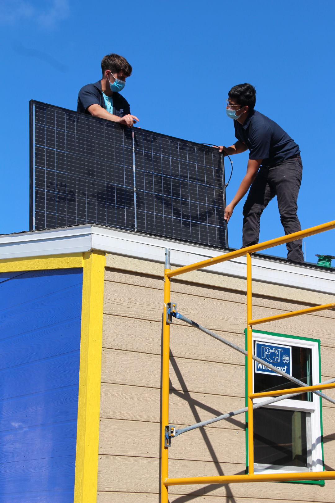 Students installing solar panels on the tiny home.