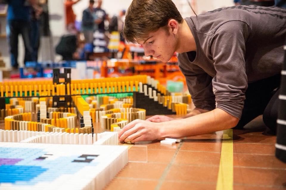 Domino Master, Nathan Heck building a domino structure on the floor.