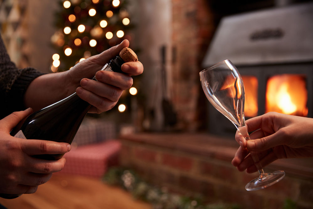 popping Champagne with a Christmas tree in the background