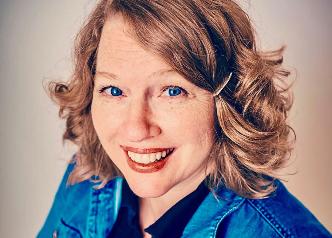 A headshot of a smiling woman.
