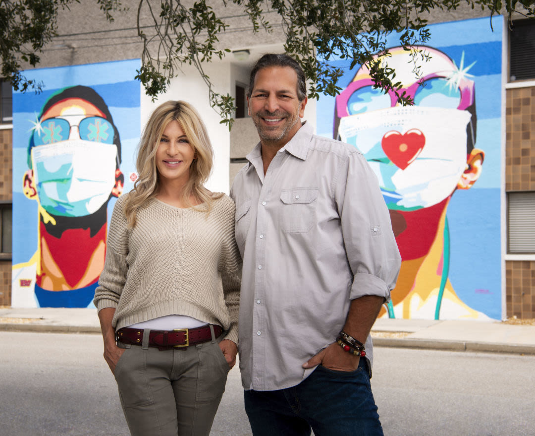 Donda Mullis and Ronnie Shugar in front of the "Sarasota Heroes" mural at their corporate headquarters on Second Street.