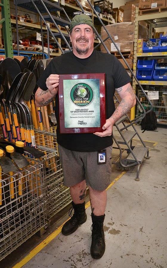 Sarasota County Materials Management team member Ted Monaghan holds the 2020 Top Green Provider Award from Food Logistics.