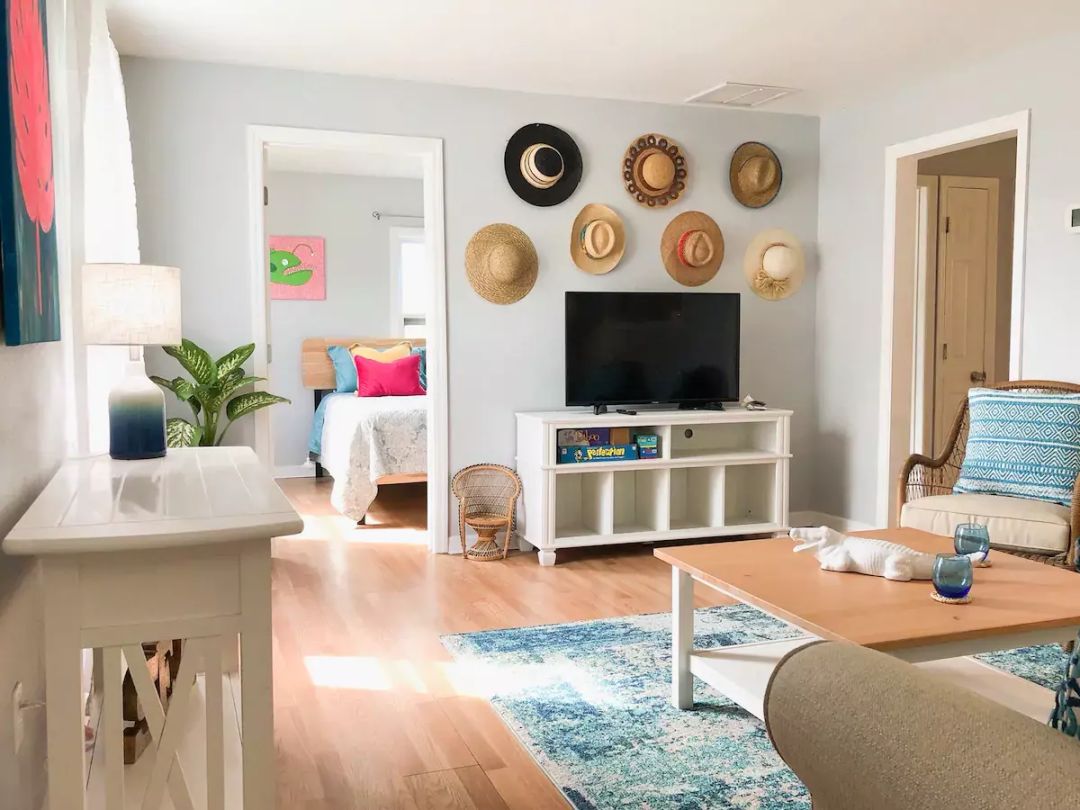 We’re charmed by this hat-decorated wall, beachy color scheme and fun art pieces.