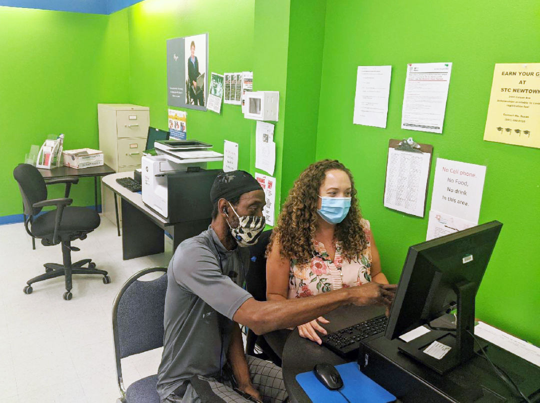 Goodwill mission services program administrator Antonia Quiros assists community member Gregory Morrison at Goodwill's Selby Newtown Job Connection office