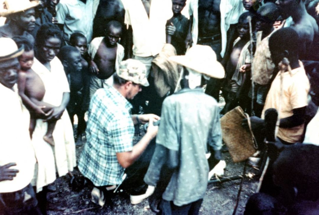 People gather as Cathcart examines snakes in Limbe, Haiti, 1968