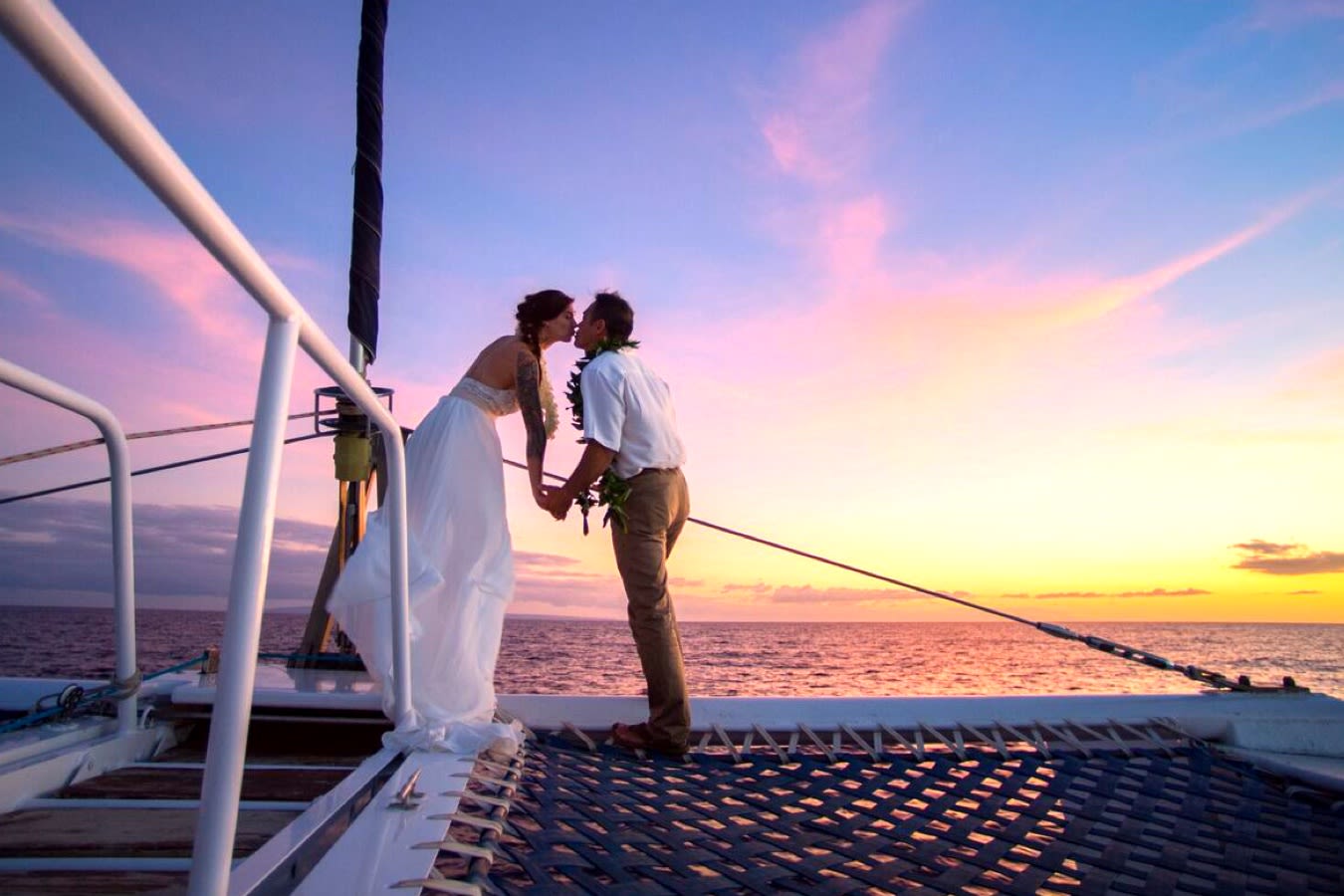 5@2x bride & groom kissing at sunset on trilogy boat
