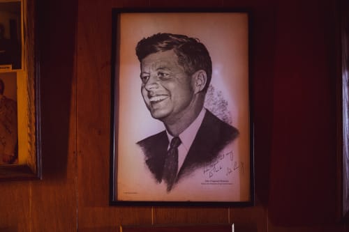 handing frame of John F. Kennedy on a wall