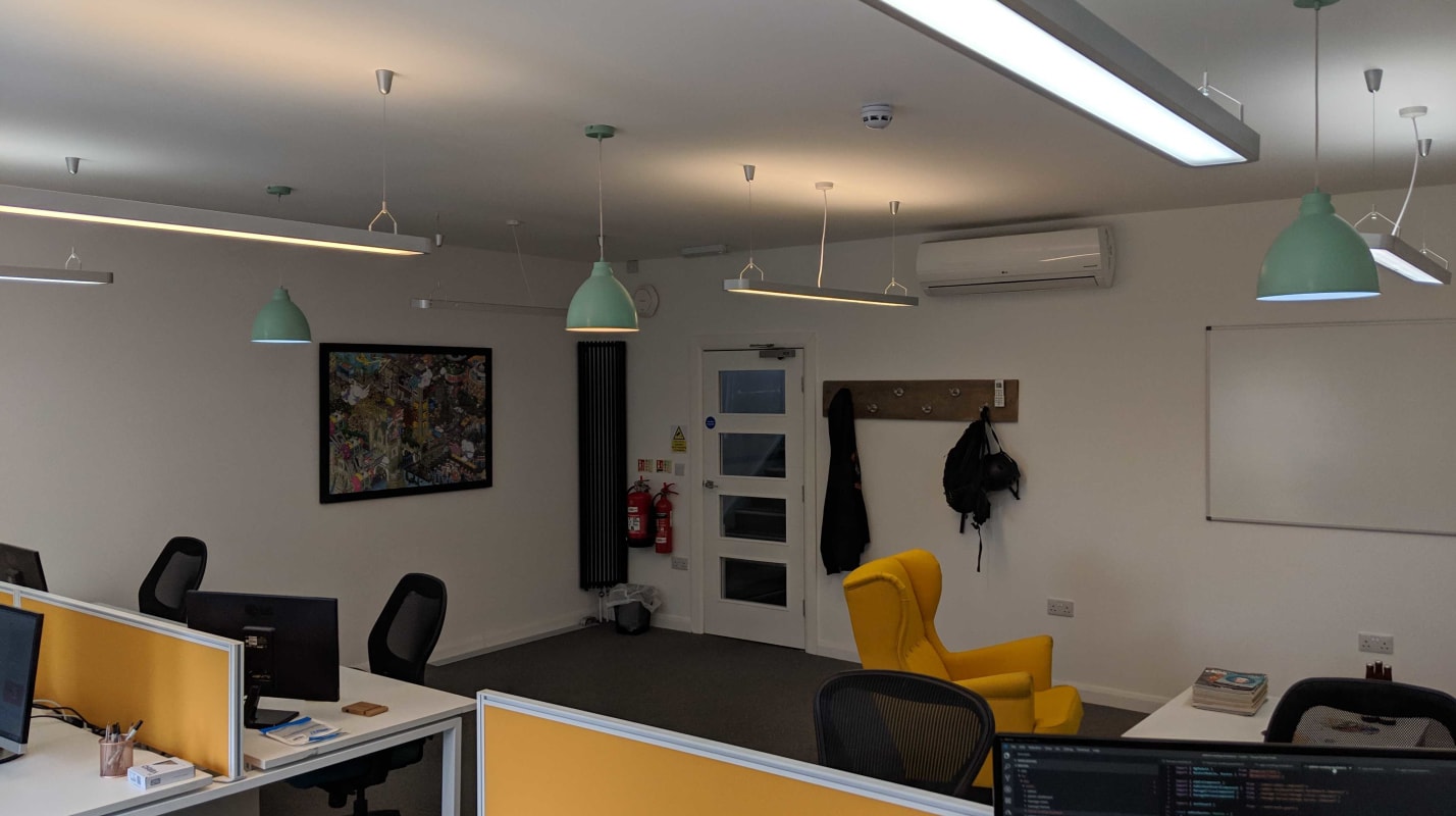 The BuddieUp studio showing desks with yellow accents.