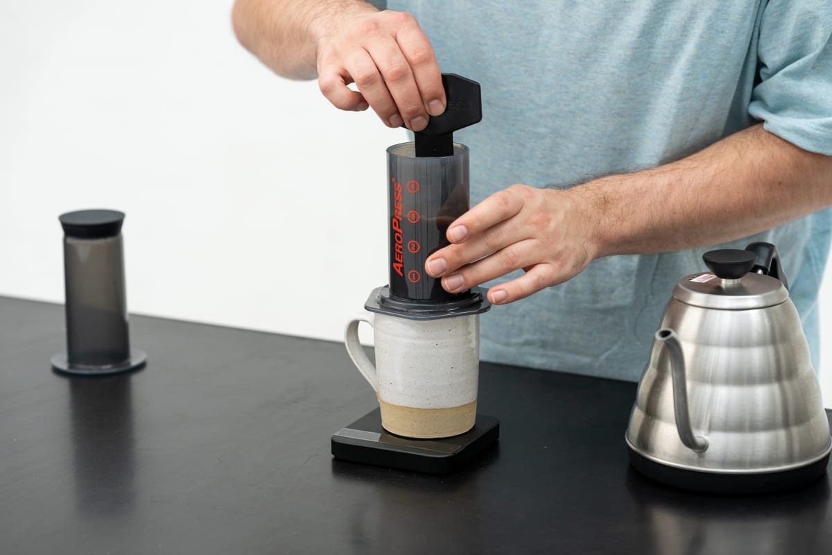 https://res.cloudinary.com/sample-coffee/image/fetch/c_fill,f_auto,q_auto,g_faces,w_1200/https://static.samplecoffee.com.au/brewguides/aeropress/AEROPRESS_STANDARD-08.jpg