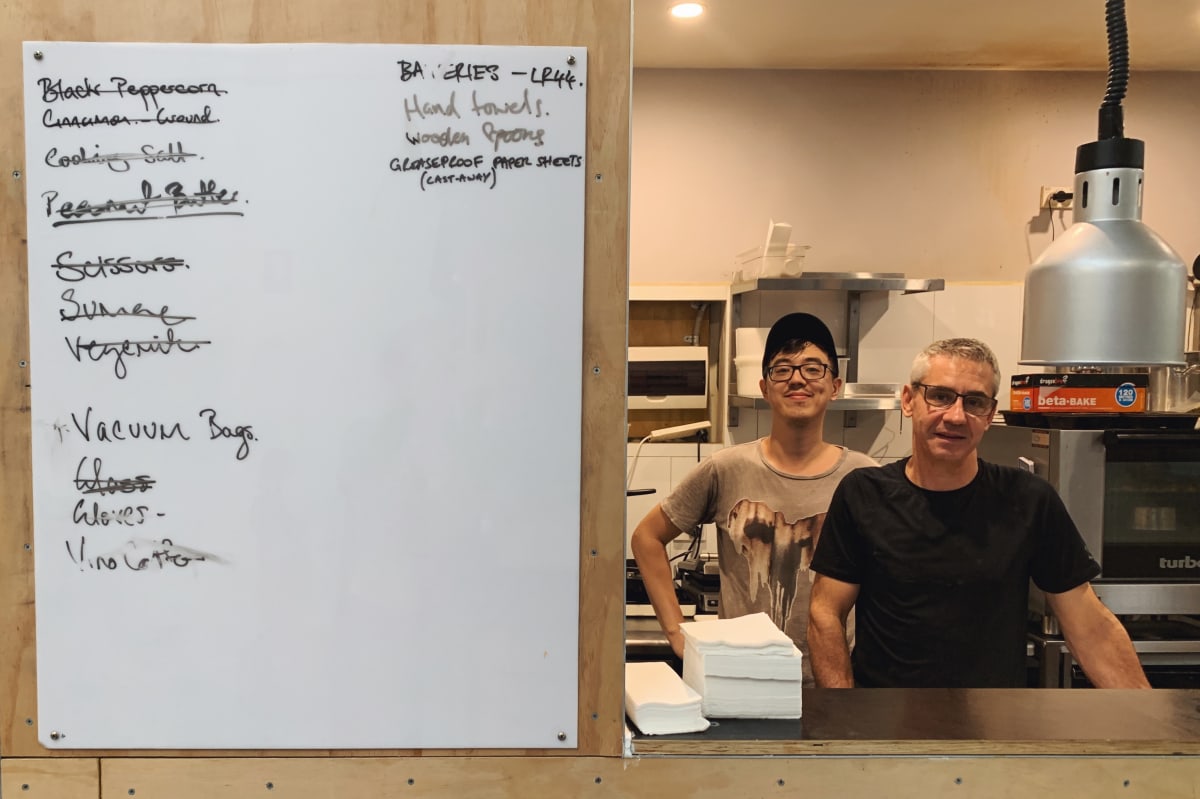 A chef at Sample’s kitchen with the updates board