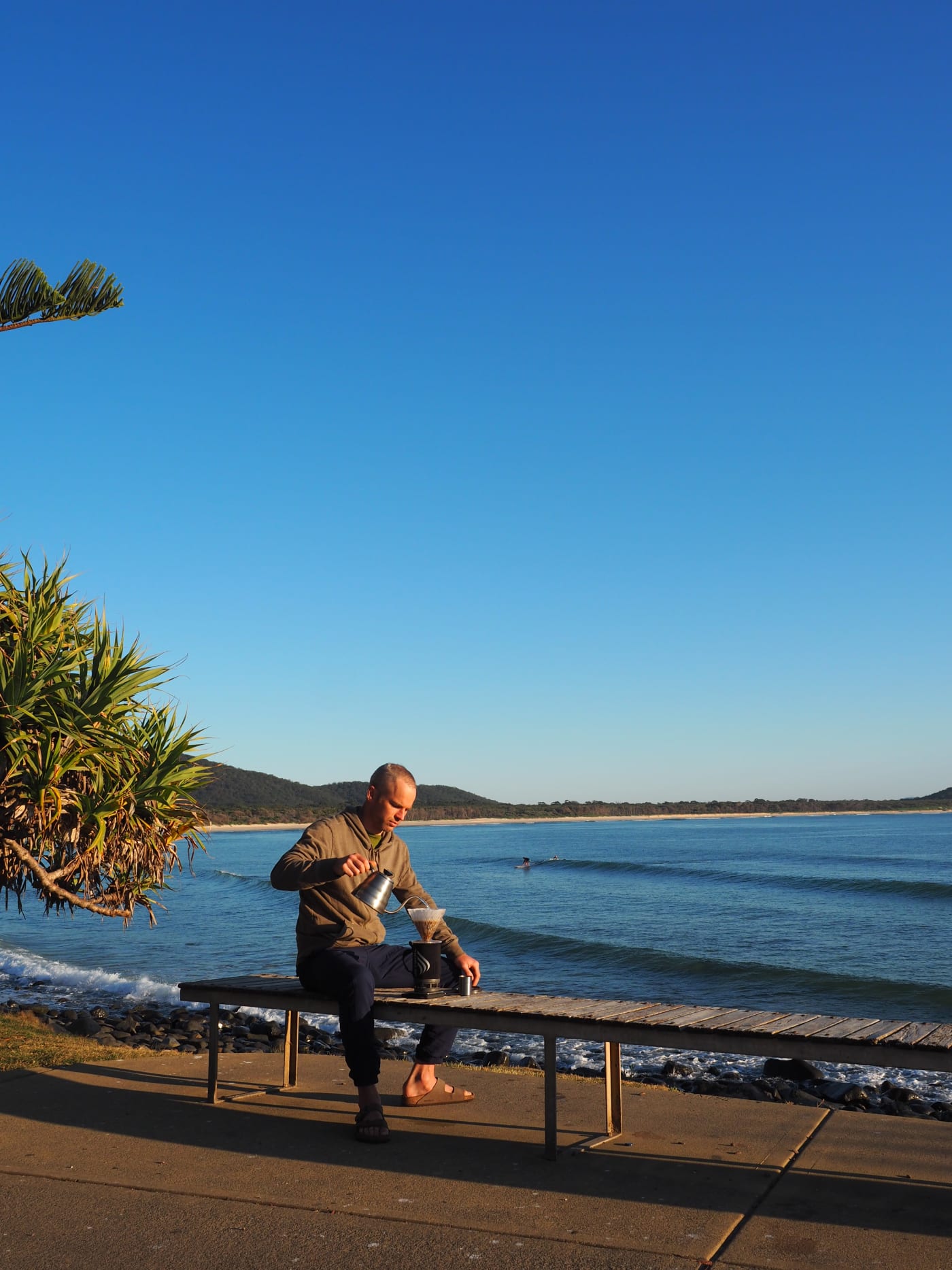 Reuben brewing coffee in a surf break in NSW. Beautiful blue sky, not much surf though.