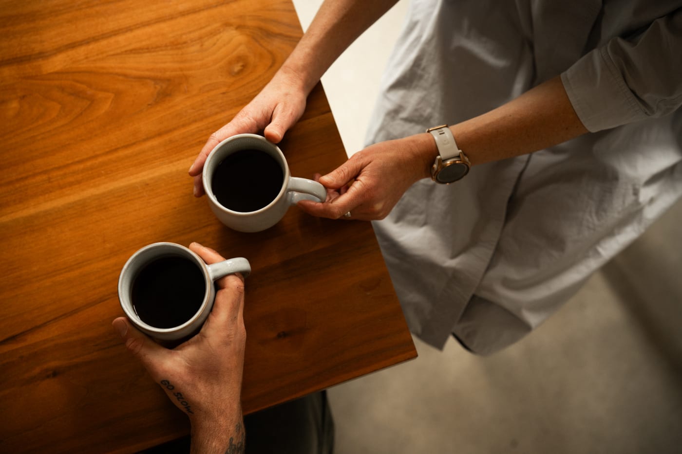 Two people sharing a filter coffee at a table.