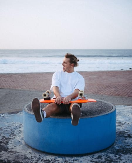 man holding a surfskate in its hands