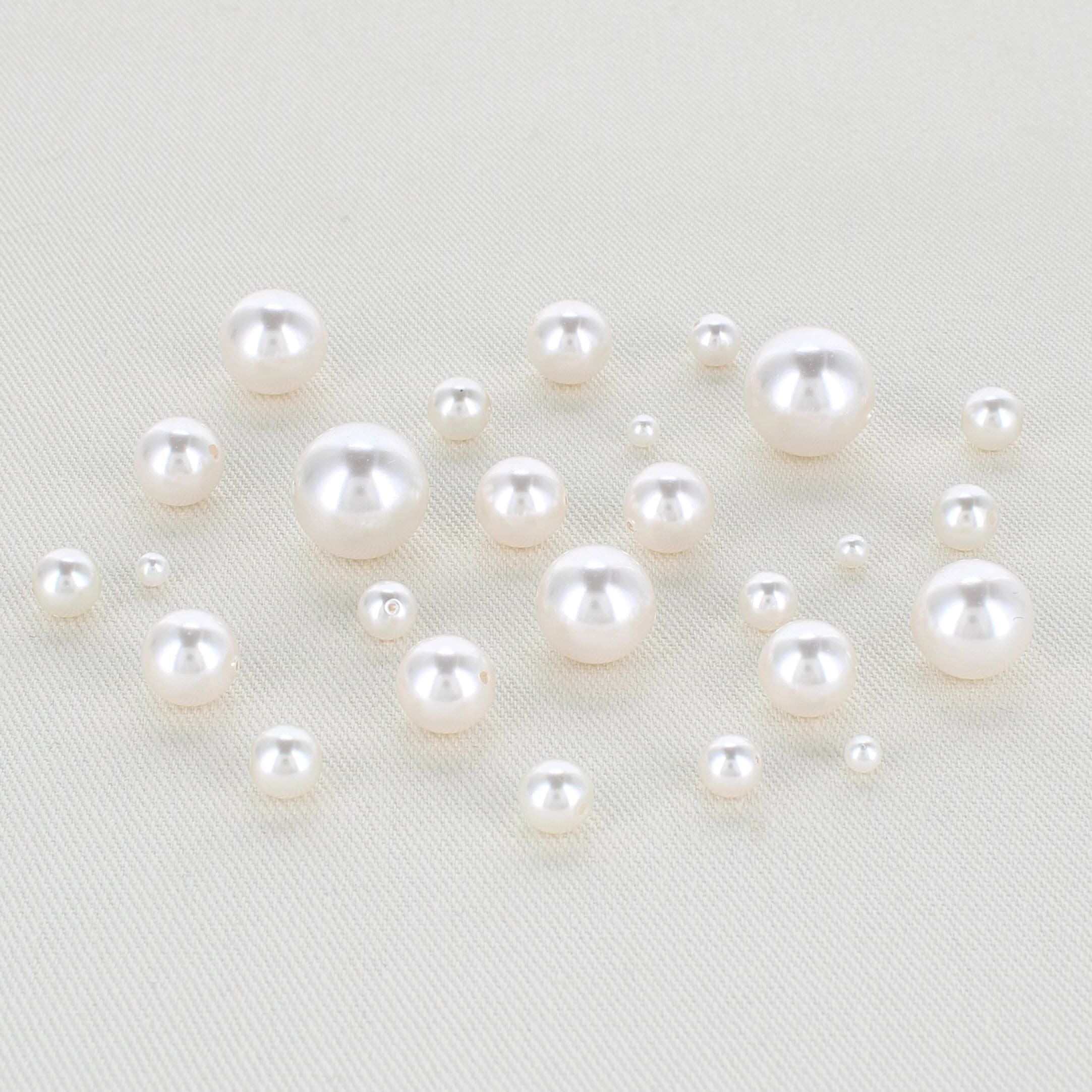 off white round pearls in multiple sizes sitting on a table