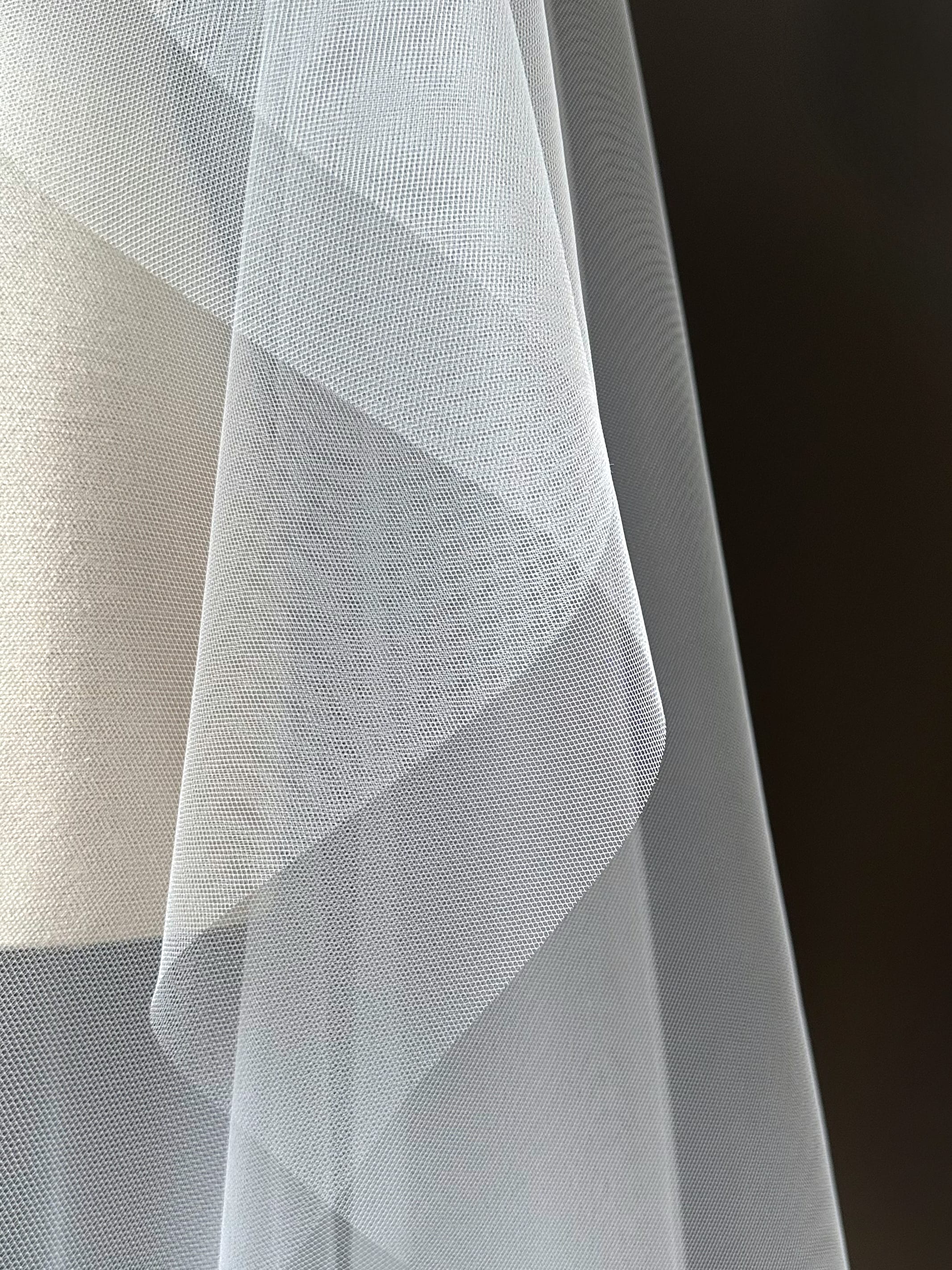 light ivory tulle fabric wedding veil on mannequin with black background