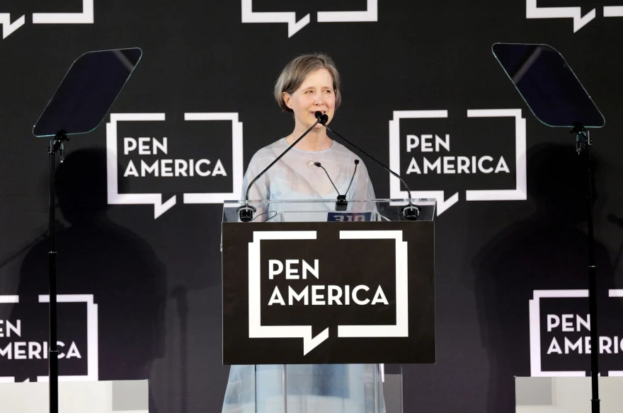 Person speaking at a podium with "PEN America" logo in the background, flanked by teleprompters.