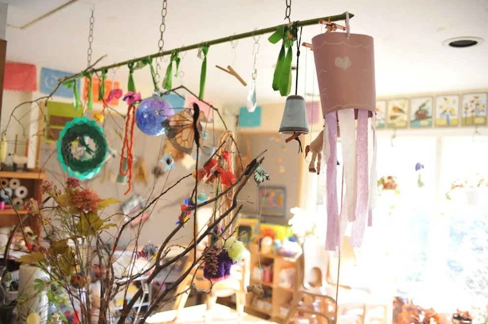 Bright, colorful craft room with hanging handmade decorations and sunlit windows.