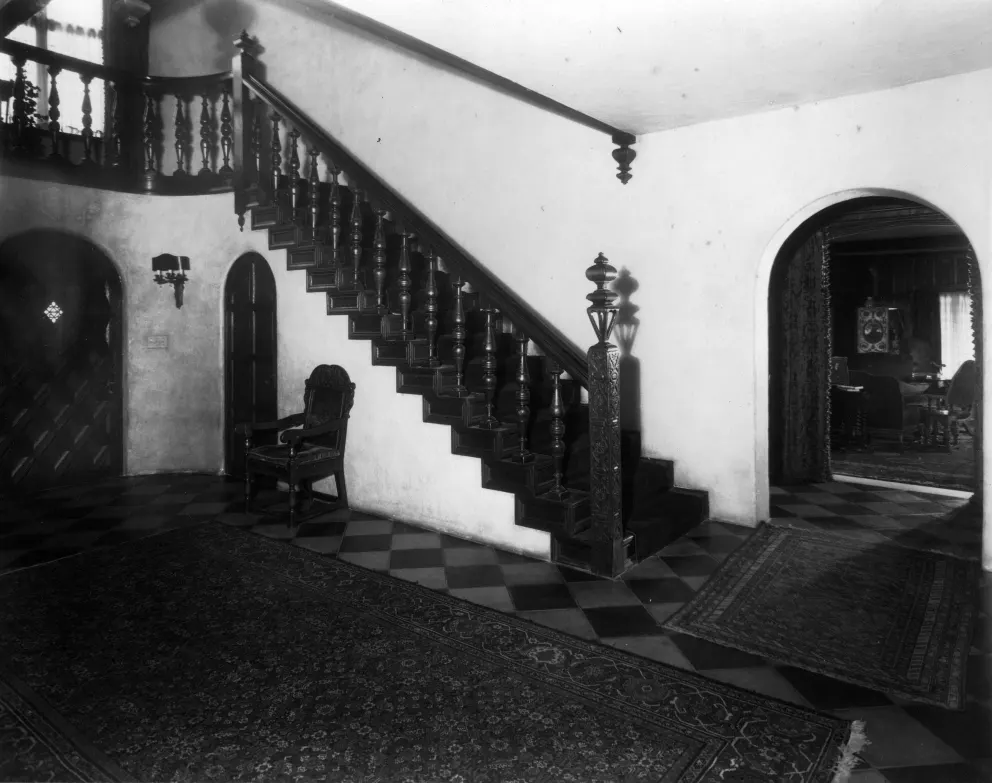 Vintage interior with staircase, chair by the wall and patterned floor.