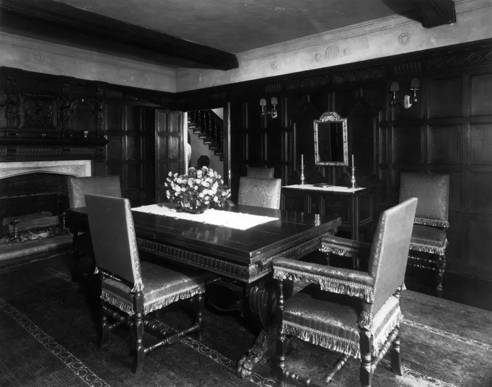 Vintage room with ornate furniture, a fireplace, and a staircase.