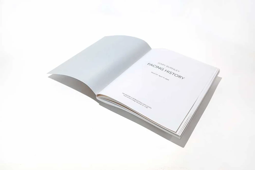Open book on a white surface with the title "FACING HISTORY" visible on the right page.