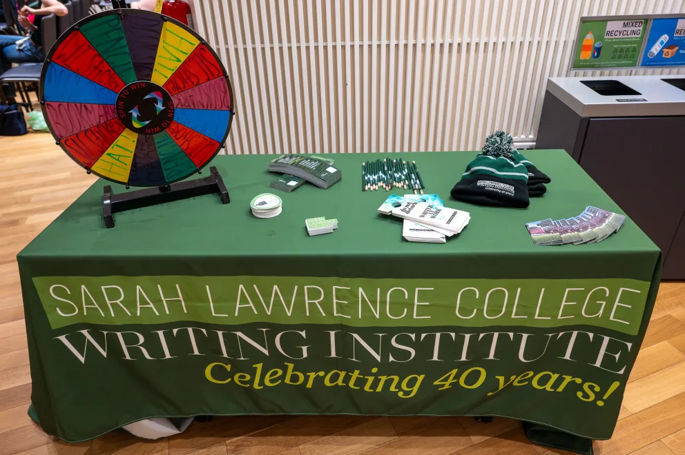 a table with a green table cloth with writing and accessories on it and a spinning wheel on top of it