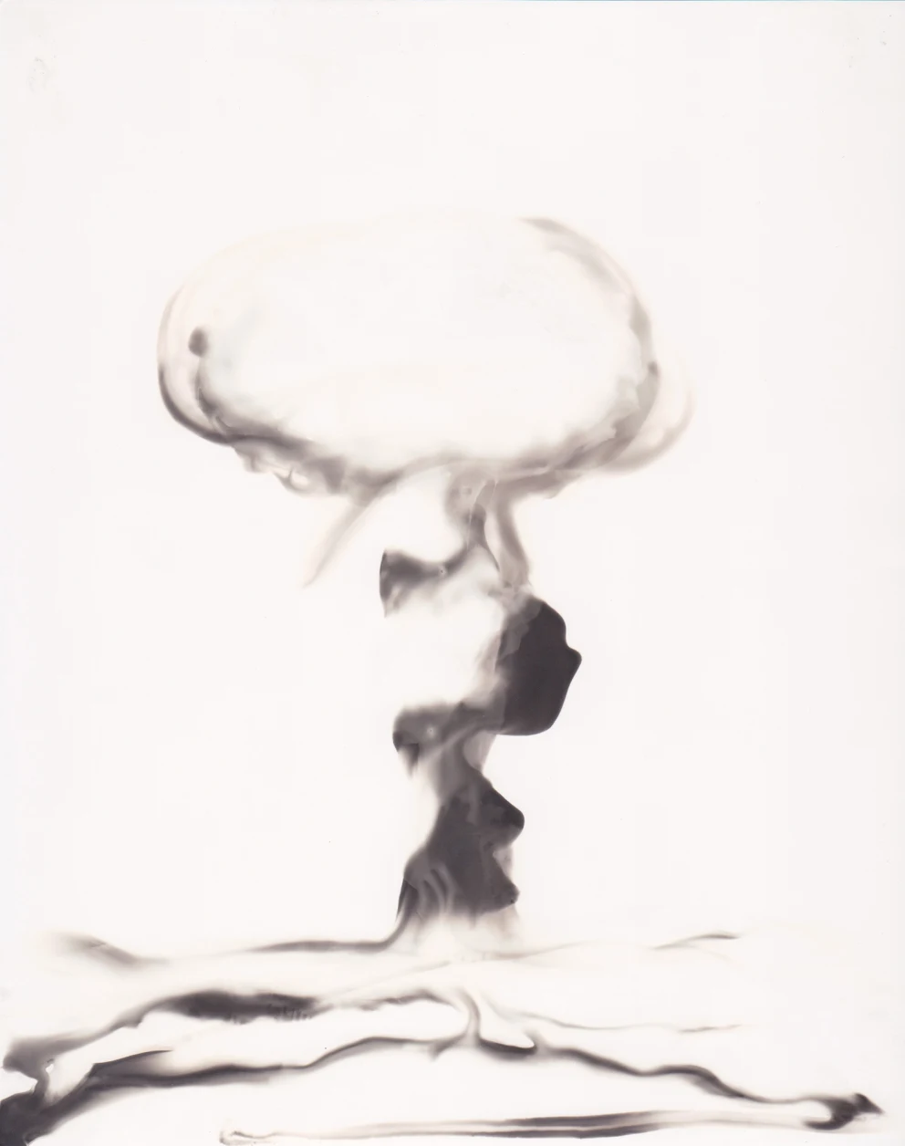 Abstract black and white image depicting a mushroom cloud shape against a light background.