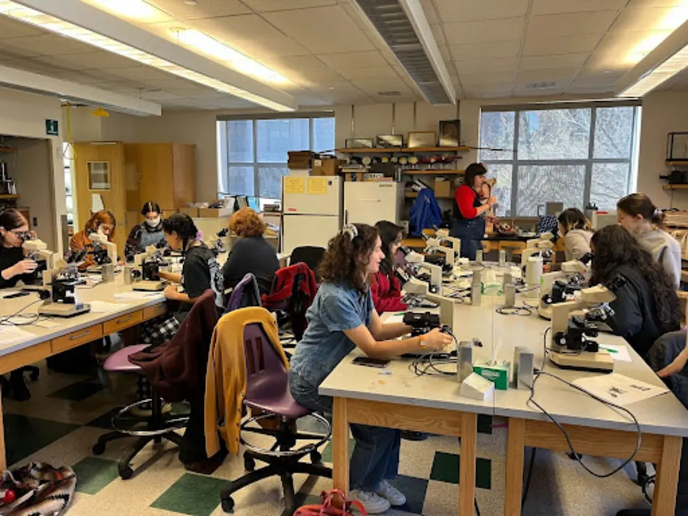 a group of people working in a lab with microscopes and microscopes on the tables and on the floor