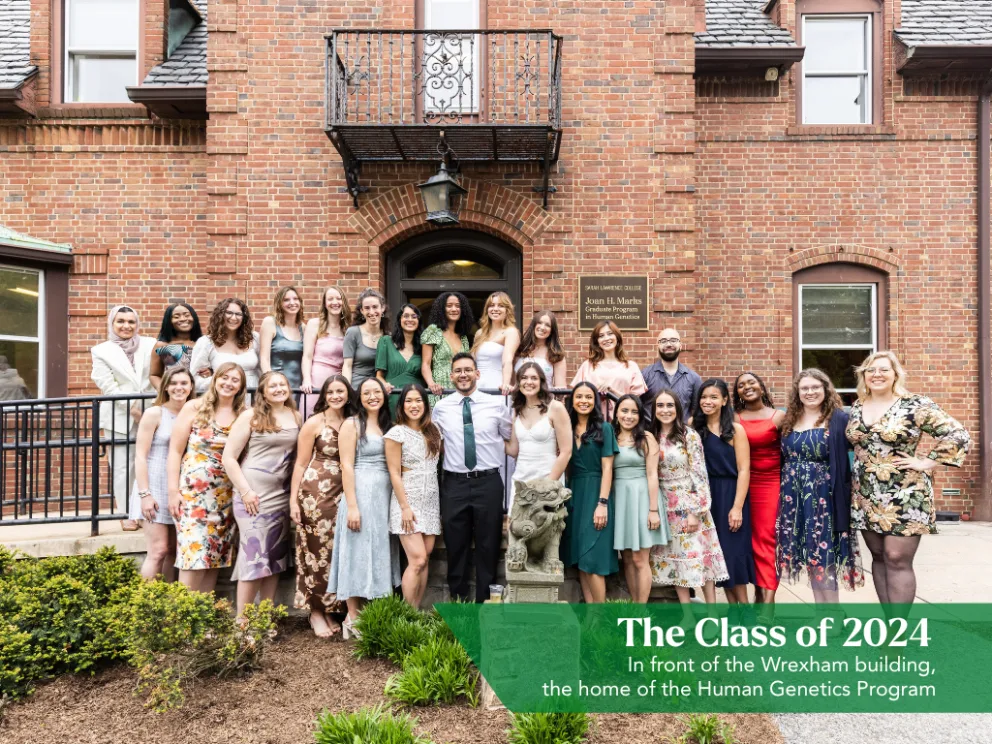 A group of people in formal attire stands in front of a brick building labeled as the home of the Human Genetics Program, Class of 2024.