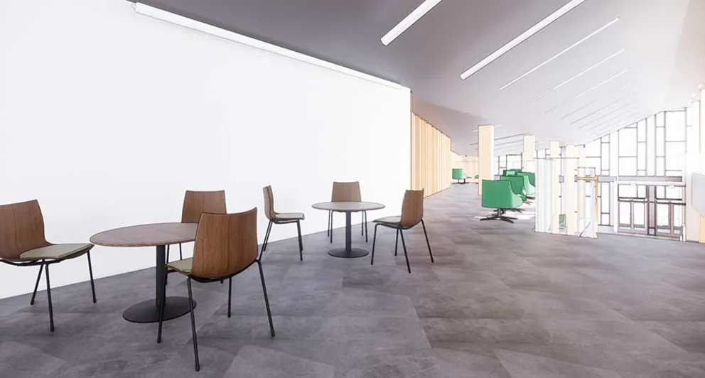 Spacious modern lounge with round tables and chairs on the left, green chairs and large windows on the right, creating an airy atmosphere.